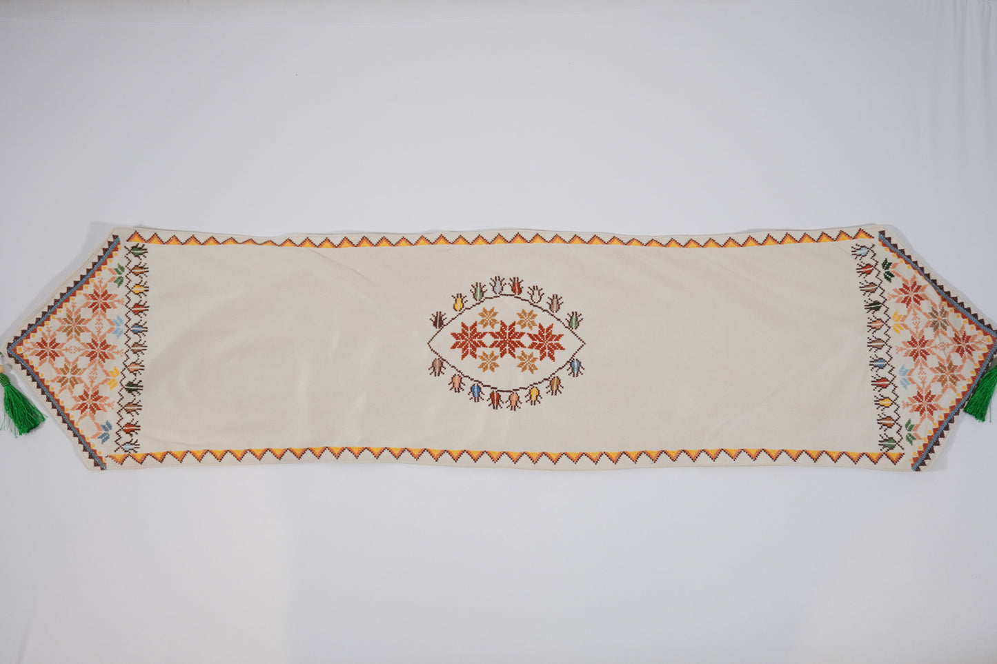 Hand-embroidered suede table runners featuring elegant Palestinian tatreez floral and geometric designs on turquoise and beige backgrounds, handmade by Palestinian, Jordanian, Lebanese, and Syrian women artisans seeking financial independence while preserving regional heritage.