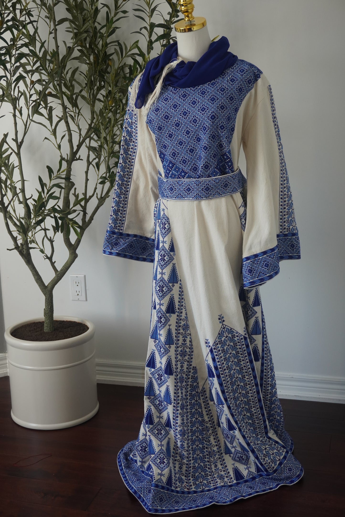 Hand-embroidered navy thoub from Yata Al Khalil, West Bank, featuring intricate designs on batiste fabric, complete with a matching head scarf, an embroidered belt, and a plain silk belt.