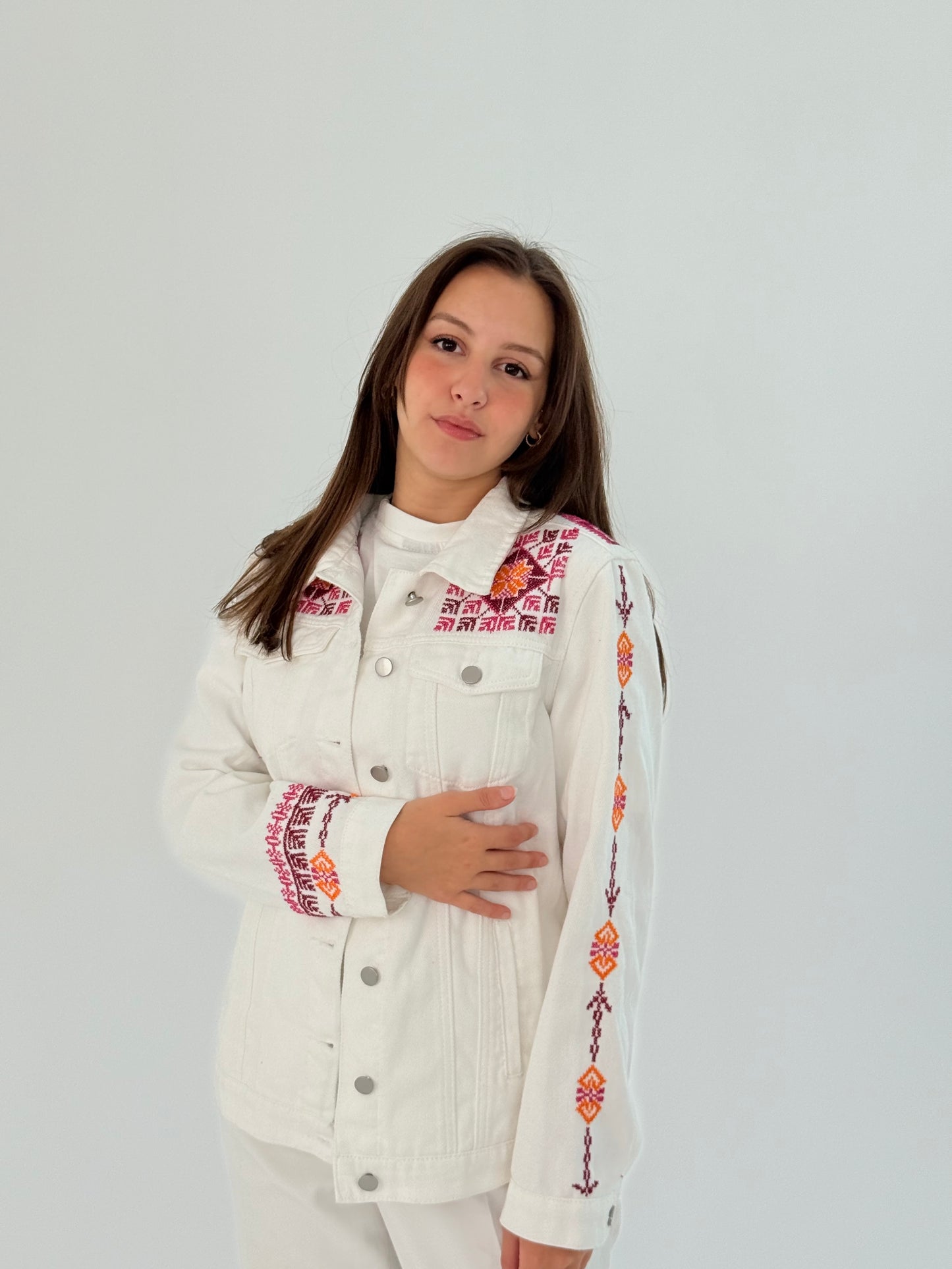 Handmade white jeans jacket with red embroidery on shoulders, sleeves, and front, blending modern and traditional beauty.