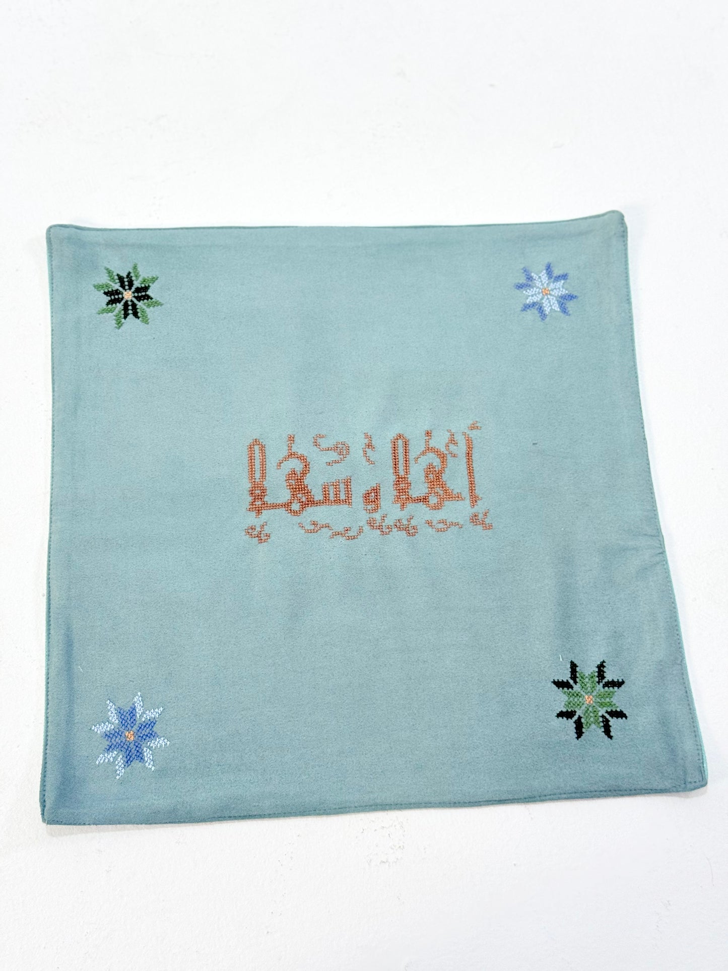 Handmade embroidered bread basket covers with traditional Palestinian tatreez in Arabic script, accented with small star motifs, crafted by women artisans in Palestine and Jordan, bringing heritage and warmth to your dining table.