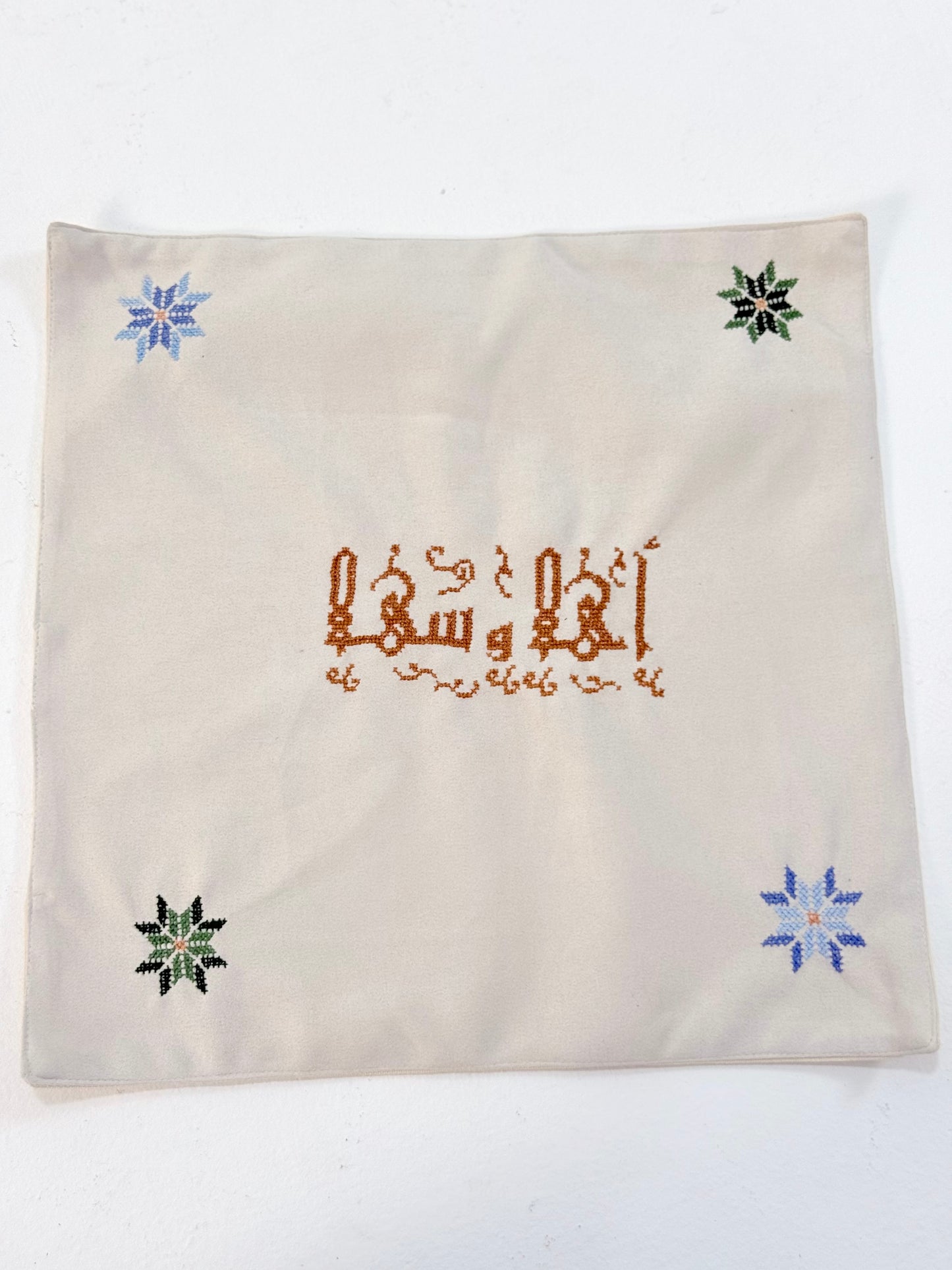 Handmade embroidered bread basket covers with traditional Palestinian tatreez in Arabic script, accented with small star motifs, crafted by women artisans in Palestine and Jordan, bringing heritage and warmth to your dining table.