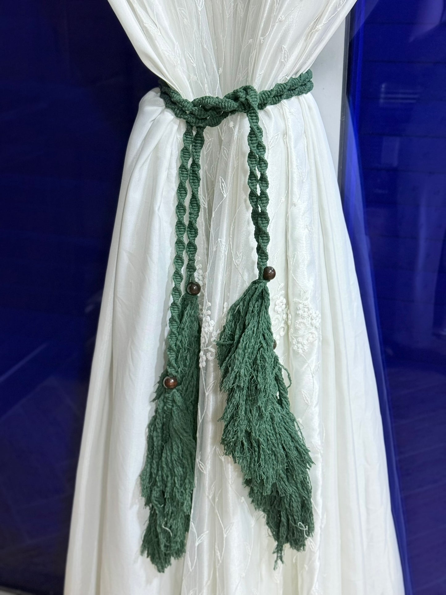 Handmade crochet curtain holders with tassels in green and cream, crafted by Palestinian women artisans, perfect for boho home decor.