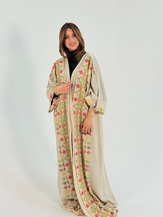 Woman wearing a long, patterned handmade by Palestinian embroidery tatreez. 