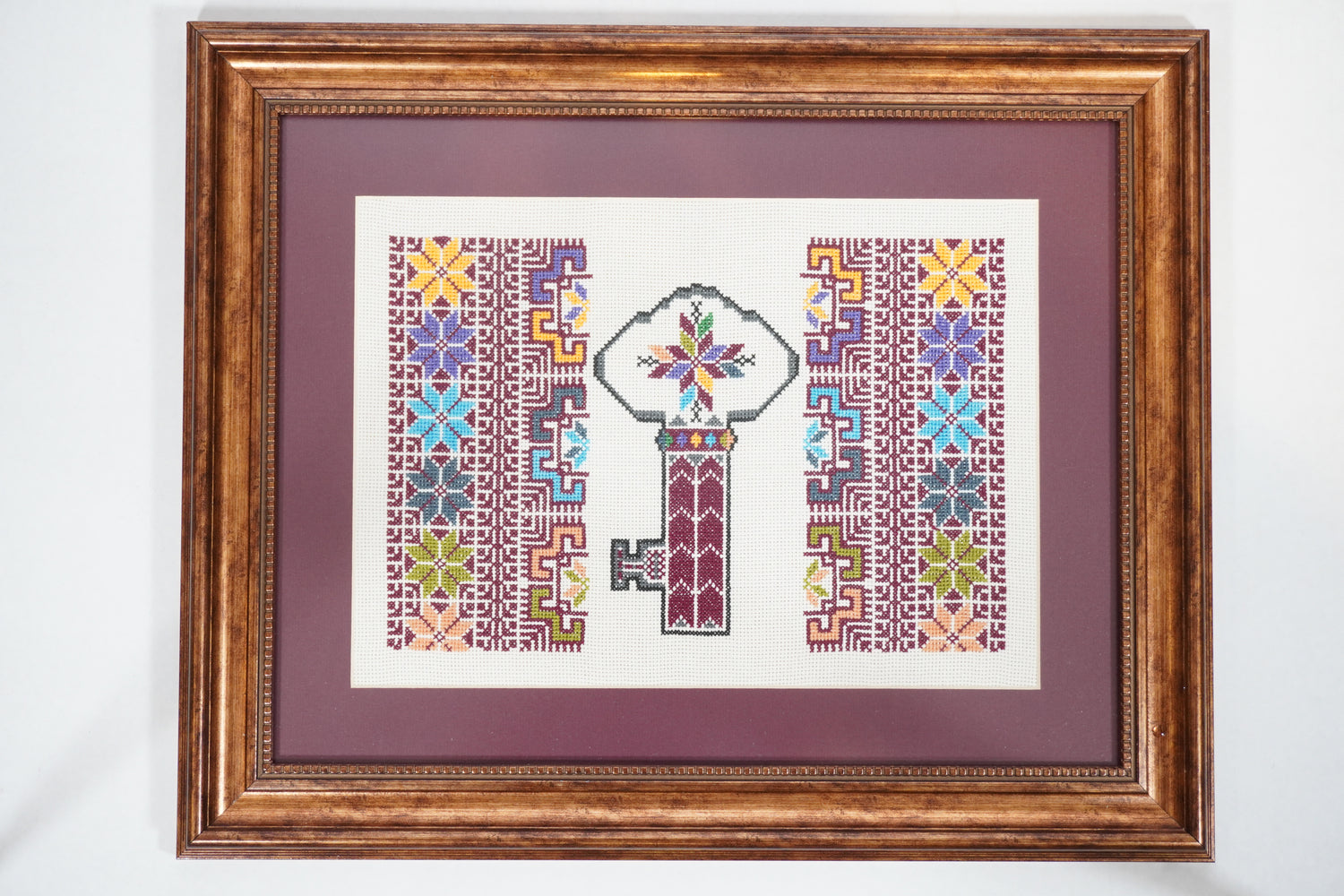 Handmade Palestinian tatreez framed artwork of “مفتاح العودة” (Key of Return), colorful embroidery symbolizing Palestinian heritage and right of return