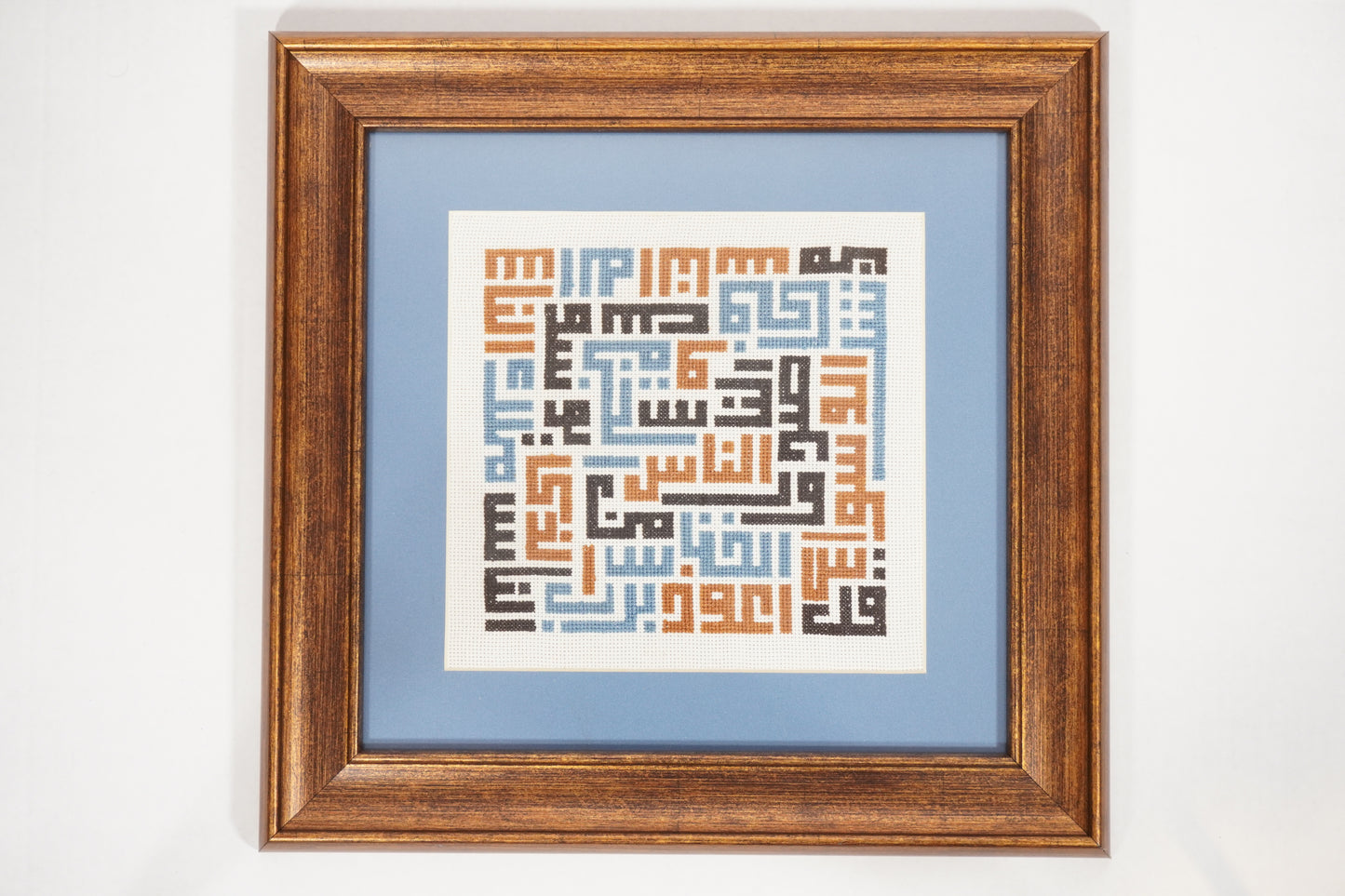 Handmade Palestinian tatreez framed artwork with “قل أعوذ برب الناس” (Say, I seek refuge in the Lord of mankind) in geometric embroidery, Islamic calligraphy home decor