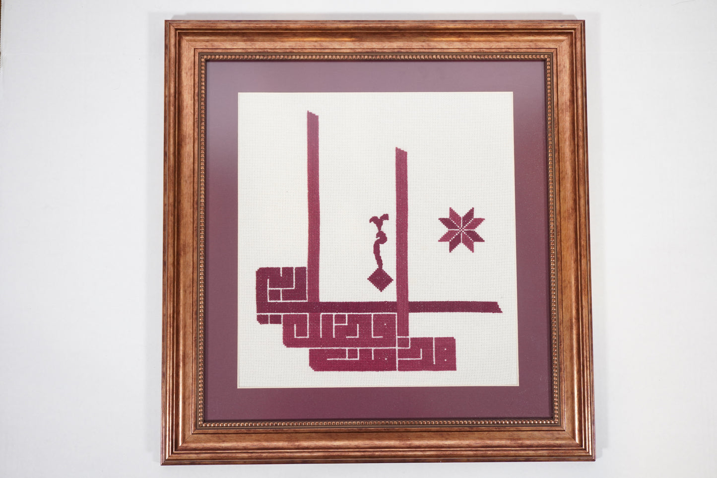 Handmade Palestinian tatreez framed artwork with “هذا من فضل ربي” (This is by the grace of my Lord) in deep maroon embroidery, elegant Islamic home decor