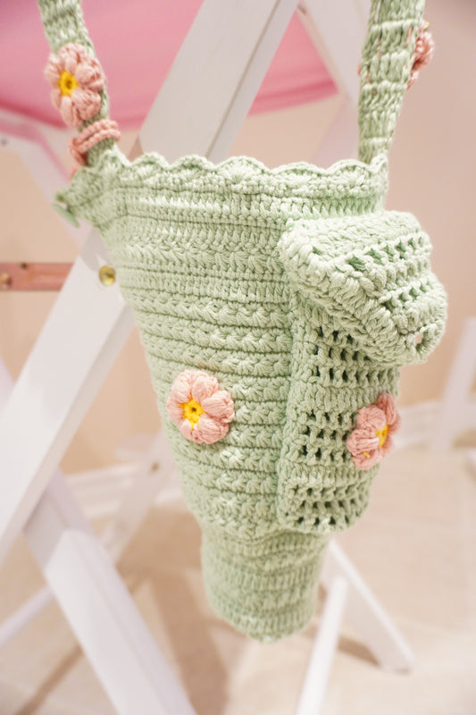 Bright green handmade crochet Stanley bottle holder with pink and yellow flowers, front pocket, and hand strap – fits 30oz, made with Alize cotton