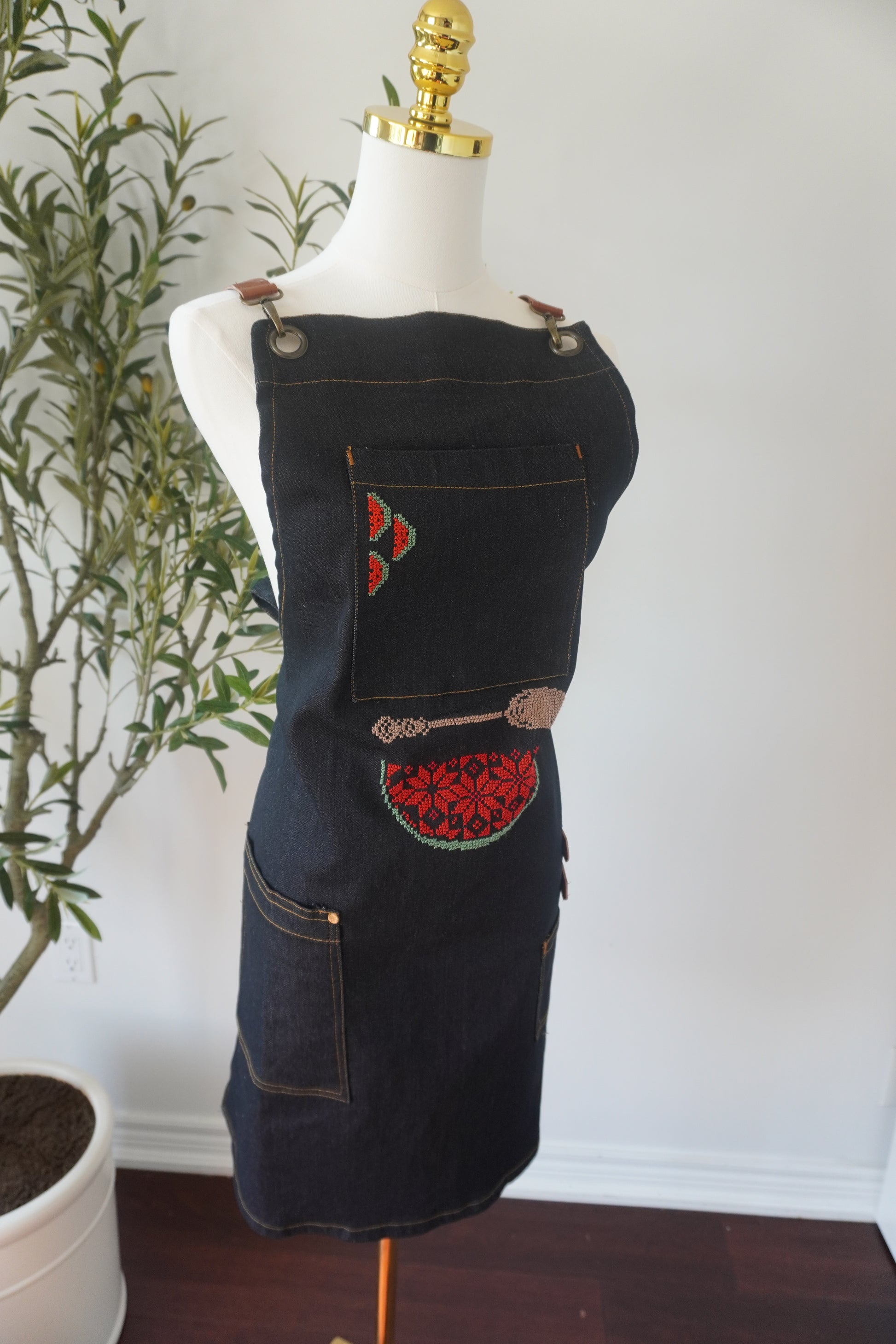 Denim apron featuring a watermelon design and beige spoon embroidery, perfect for cooking at events or barbecues.