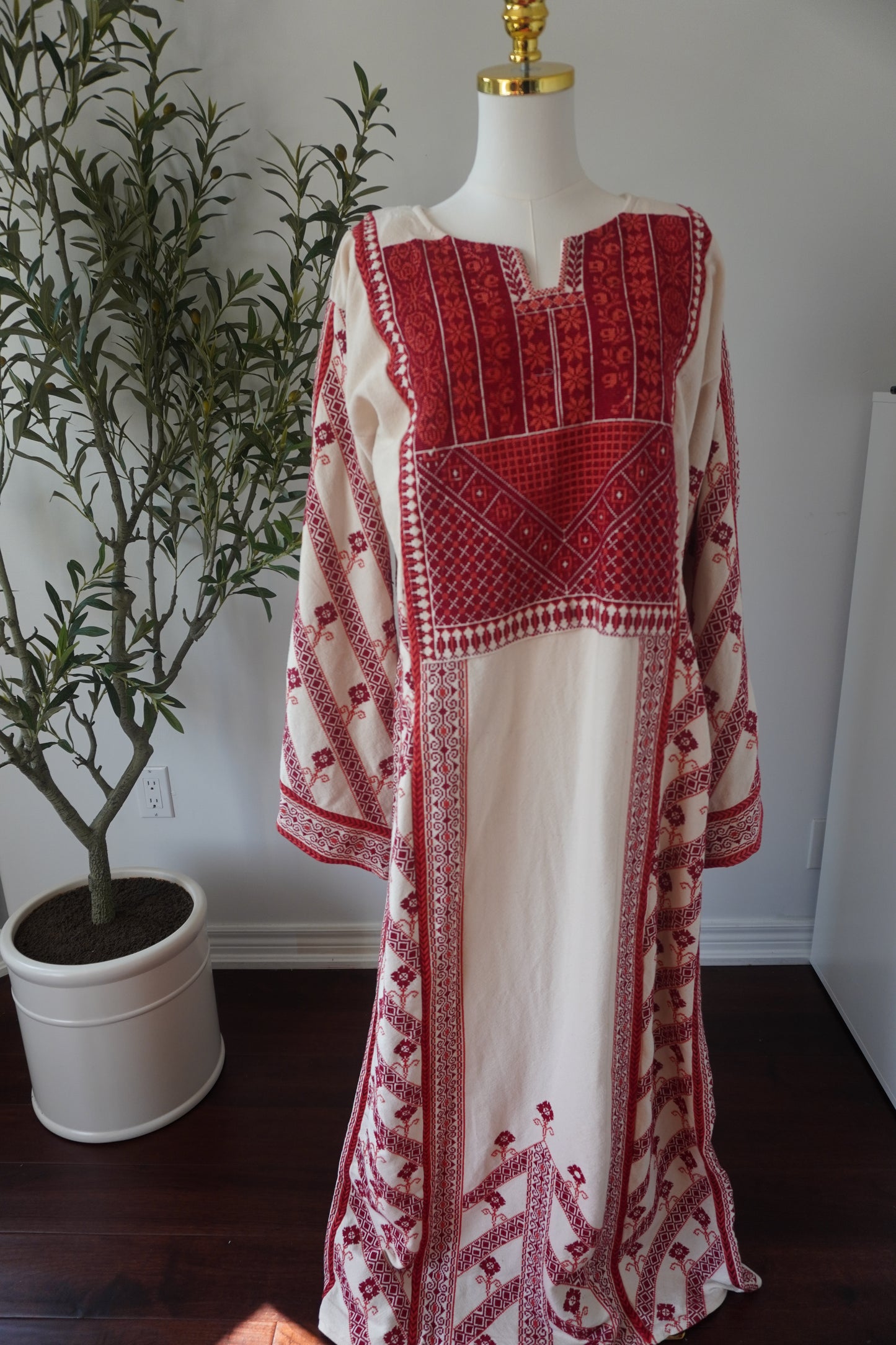 Hand-made off-white thoub from Yata Al Khalil with vibrant red and orange Palestinian embroidery. Comes with an off-white shawl with sharasheeb and a silk belt.