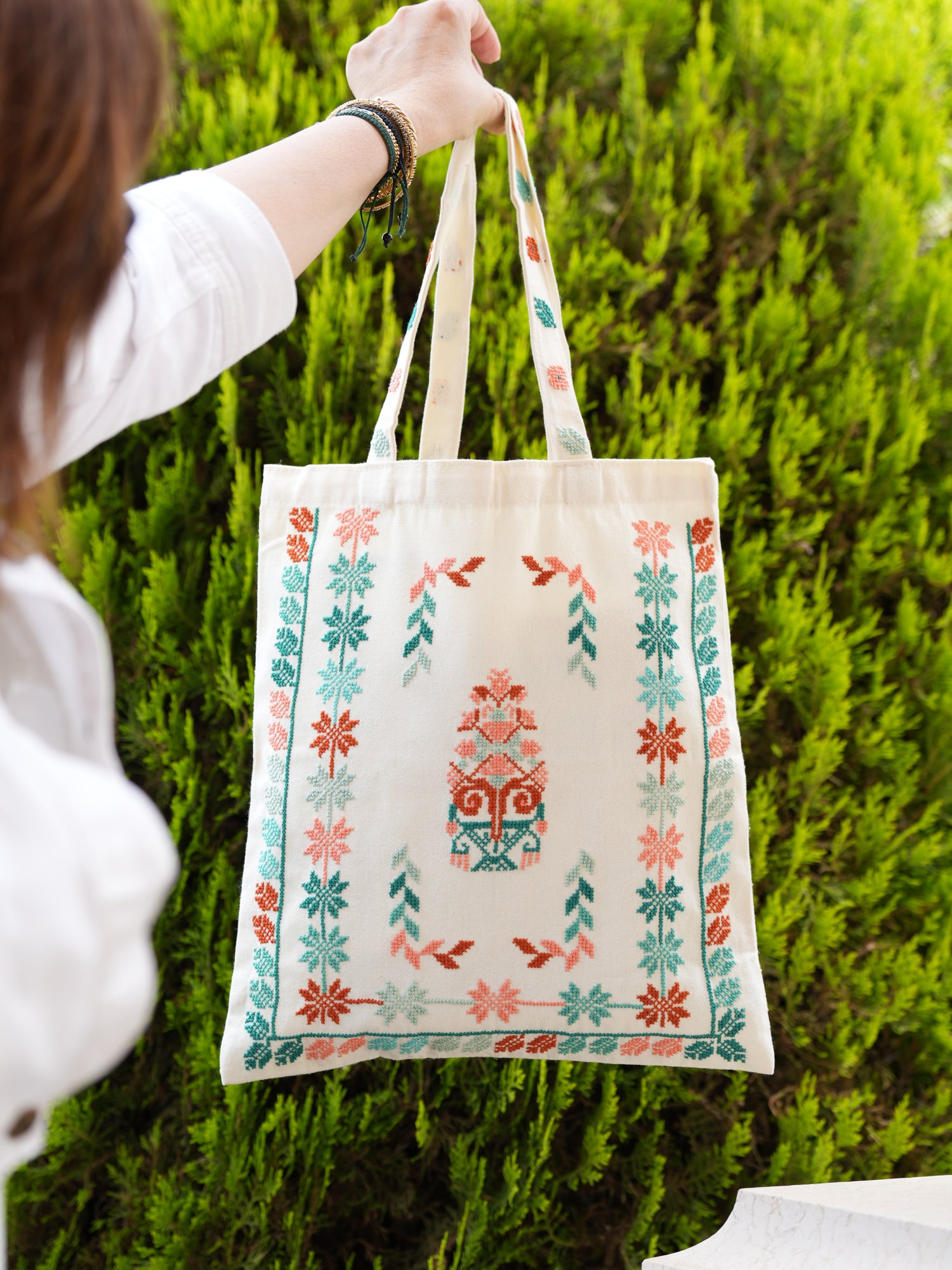Linen beige tote bag with teal and coral Palestinian tatreez embroidery, handmade by women artisans, eco-friendly and spacious.
