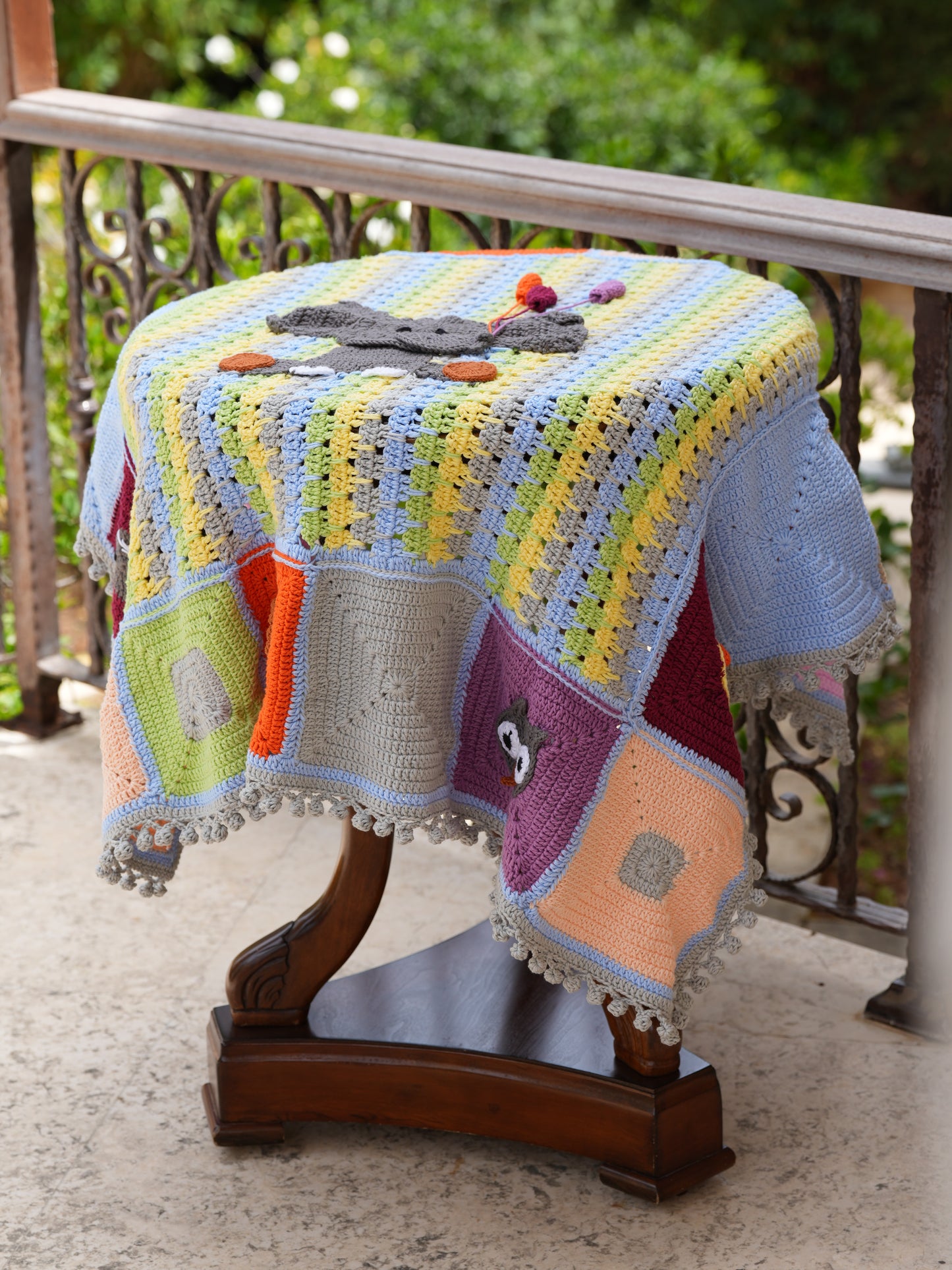 Handmade crochet baby blanket with pastel stripes, featuring a grey elephant holding colorful balloons and cute animal patches, crafted by women artisans in Lebanon, and Syria to support their livelihoods