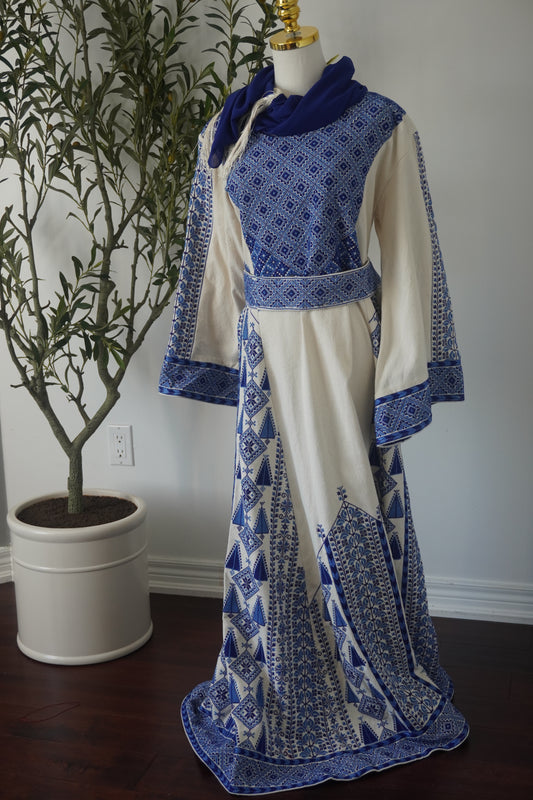 Hand-embroidered navy thoub from Yata Al Khalil, West Bank, featuring intricate designs on batiste fabric, complete with a matching head scarf, an embroidered belt, and a plain silk belt.