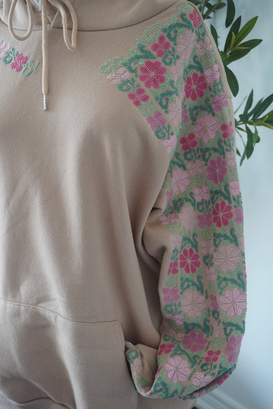 Beige hoodie featuring intricate Tatreez flower designs on the left side, crafted from a soft cotton and polyester blend.