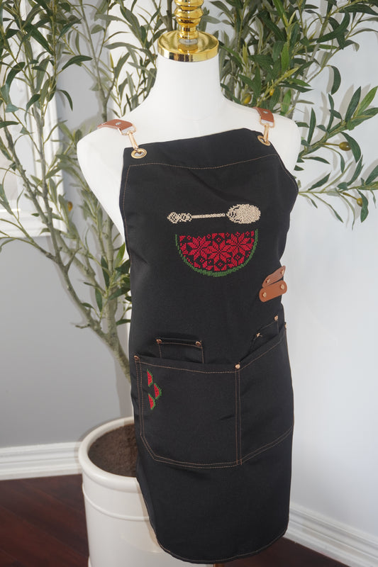 Adjustable apron with grey straps, featuring hand-embroidered watermelon design with a spoon and three cute watermelon slices on the pocket in cumon color. Includes deep front pockets and a flattering waistline