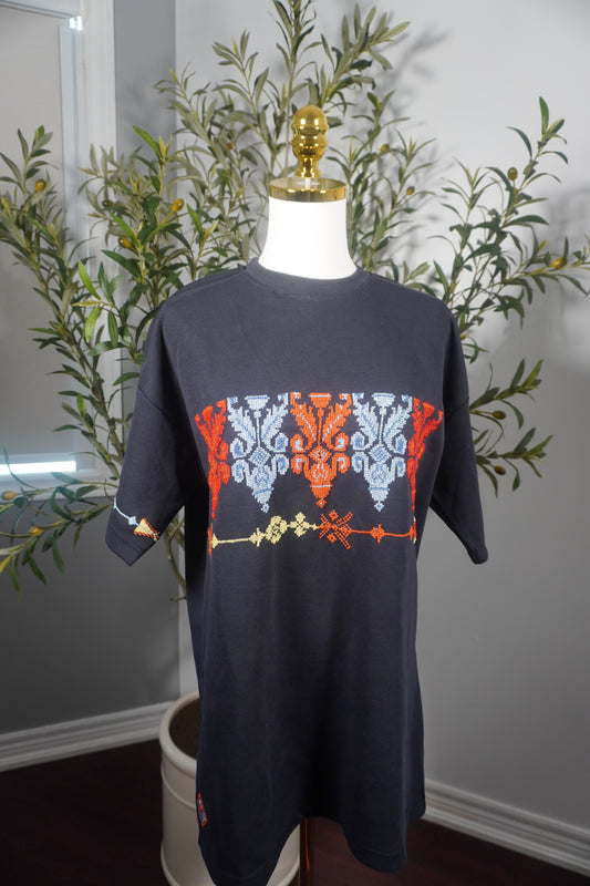 Oversized t-shirt with a single line of beautifully embroidered Kasat in bright colors and a floral design on one sleeve, showcasing unique craftsmanship.