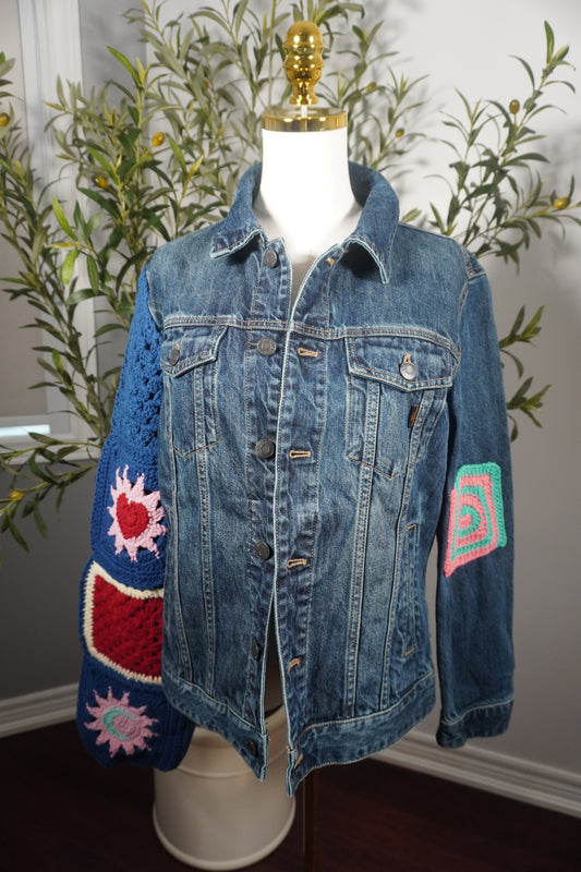 A captivating medium-sized denim jacket featuring vibrant stars and colorful moon motifs on the sleeves, with striking square patterns on the back, showcasing the craftsmanship of a Lebanese artisan.