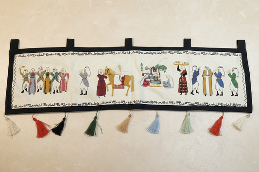 Decorative textile with embroidered figures and tassels on a wooden floor