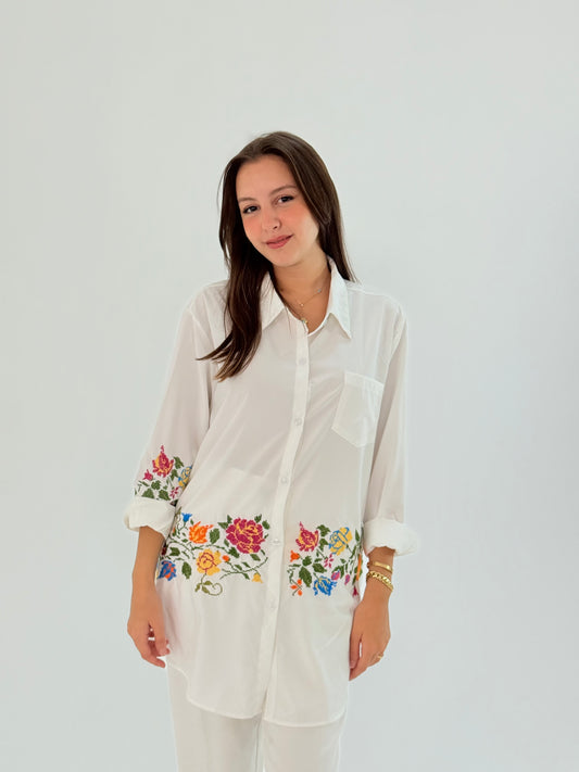 Handmade white shirt made of polin fabric with elegant floral embroidery on the bottom.