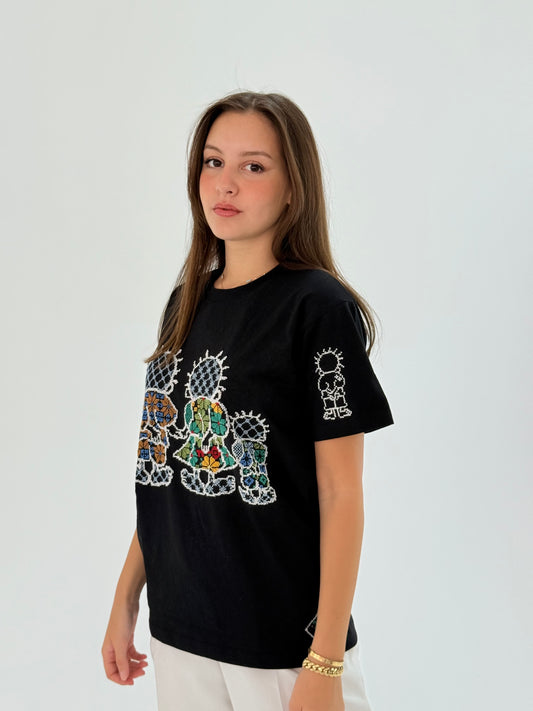Black cotton T-shirt with Handhala family embroidered in beige, green, and yellow, featuring iconic pose on the sleeve and brand logo.