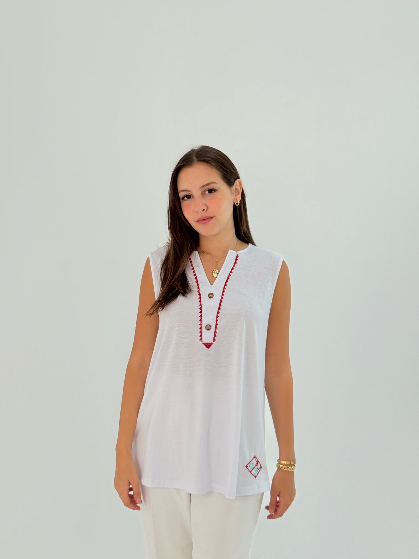 White cotton shirt with 'Ala Hathehe Elardh' design, blending modern style with traditional elements.