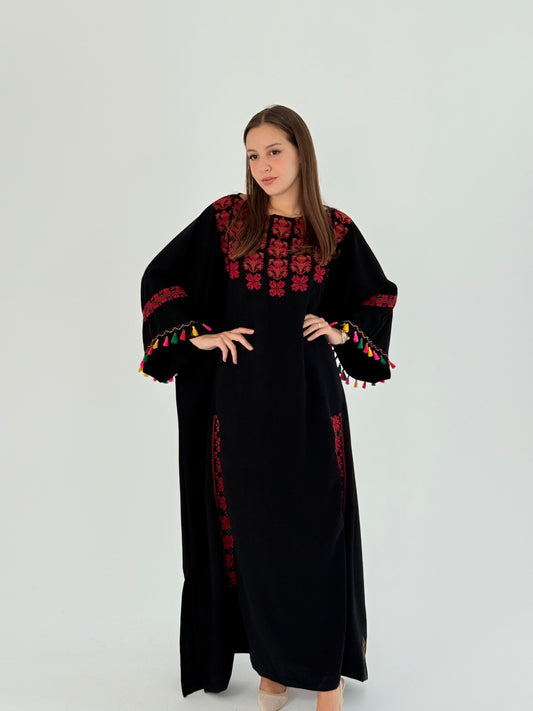 Handmade black Crepe Georgette abaya featuring Palestinian Tatreez embroidery and colorful tassel accents on the chest, hands, and sides.