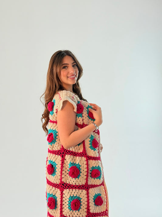 Elegant sleeveless cardigan with a floral pattern in turquoise and fuchsia, handcrafted with care and attention to detail.