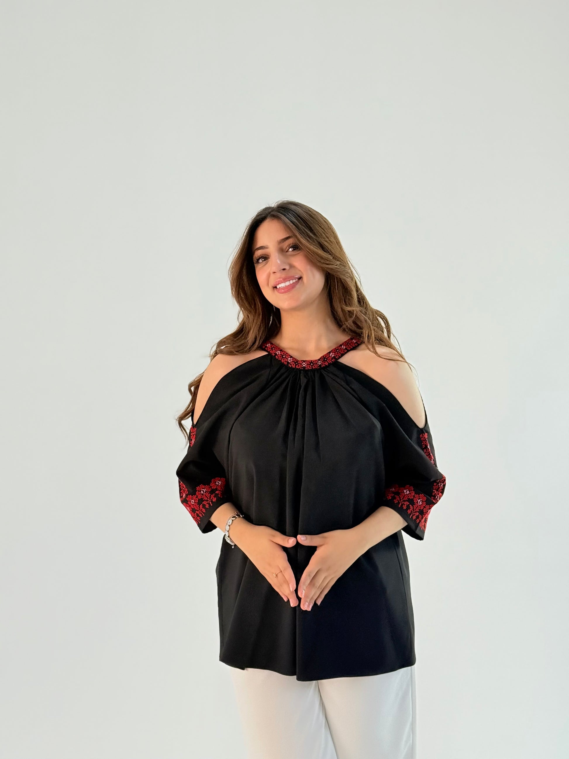 Elegant shoulder-cut top made of twill fabric featuring intricate Palestinian embroidery, showcasing unique design and artisan craftsmanship. Available for customizable pre-orders.