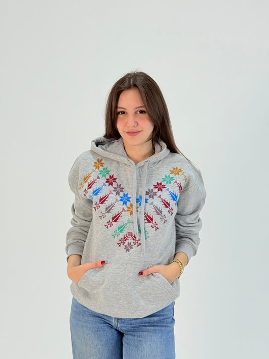 Light grey cotton hoodie with colorful Kanaan star hand embroidery, handmade by women artisans in Palestine and Jordan.