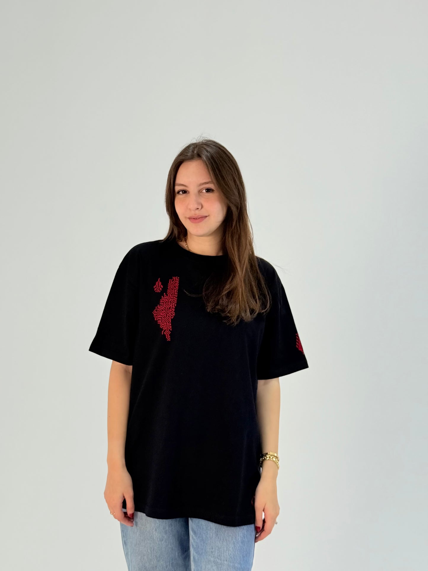 Black cotton t-shirt with handmade red Palestine map embroidery, modeled with jeans, crafted by women artisans