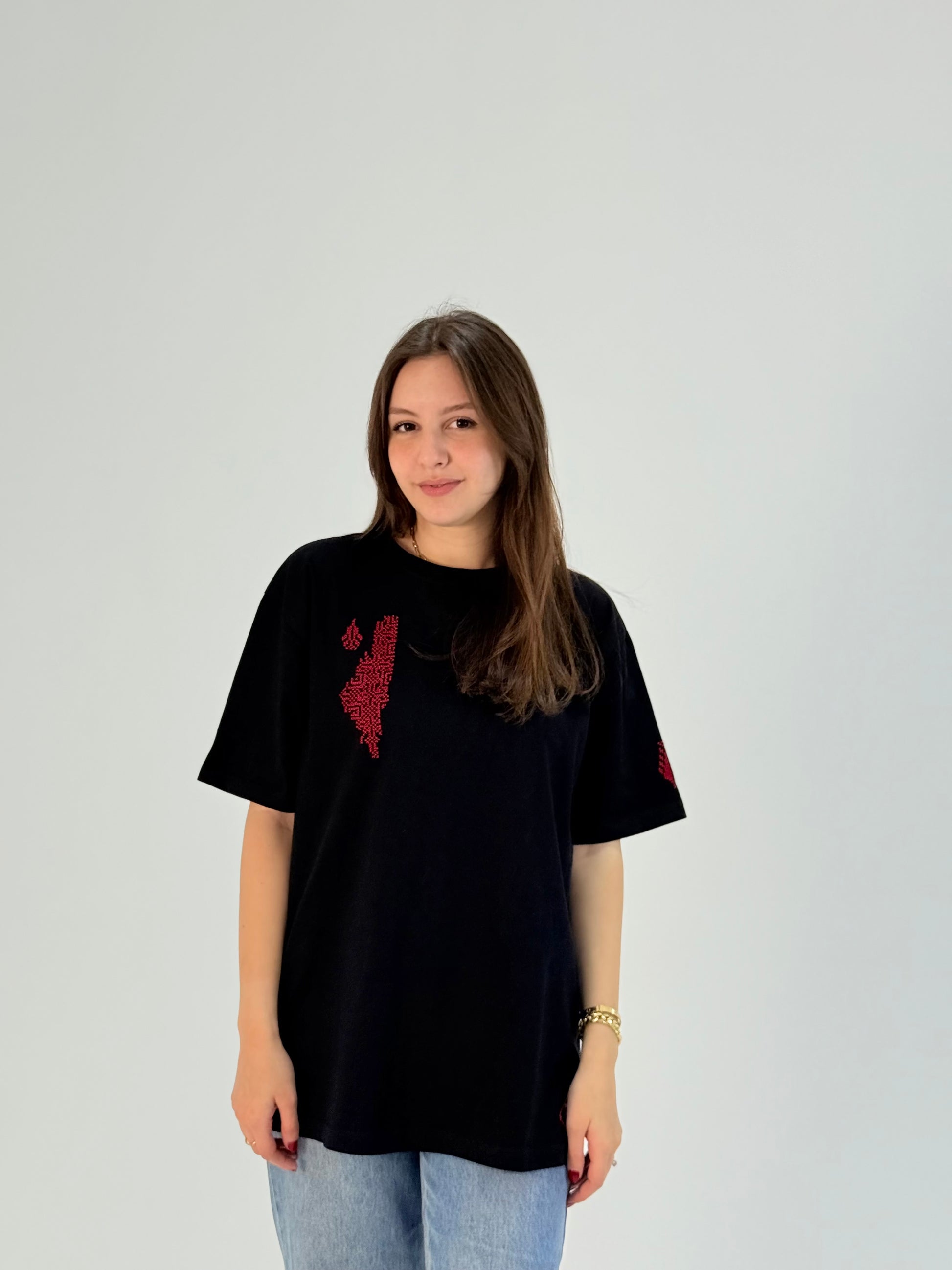 Black cotton t-shirt with handmade red Palestine map embroidery, modeled with jeans, crafted by women artisans