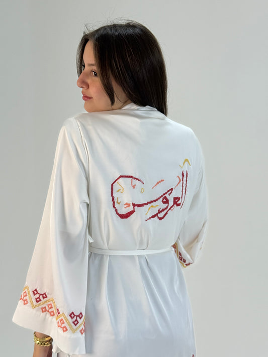 White silk bridal robe with red Palestinian tatreez embroidery and bride map design, handmade for weddings