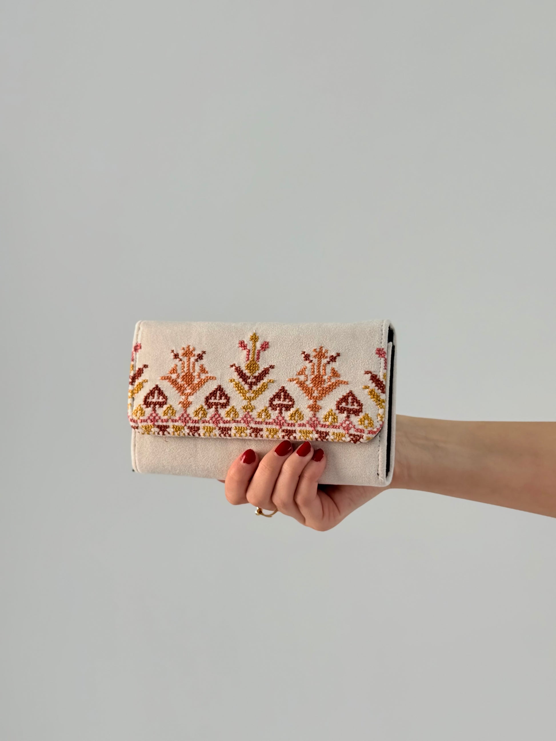 Elegant handmade suede wallet with traditional Palestinian tatreez embroidery in red and gold, perfect for daily use or gifting