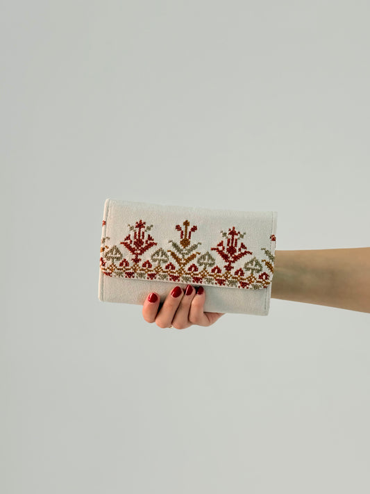 Handmade suede wallet with traditional Palestinian tatreez embroidery in red and gold, elegant and practical accessory for everyday use