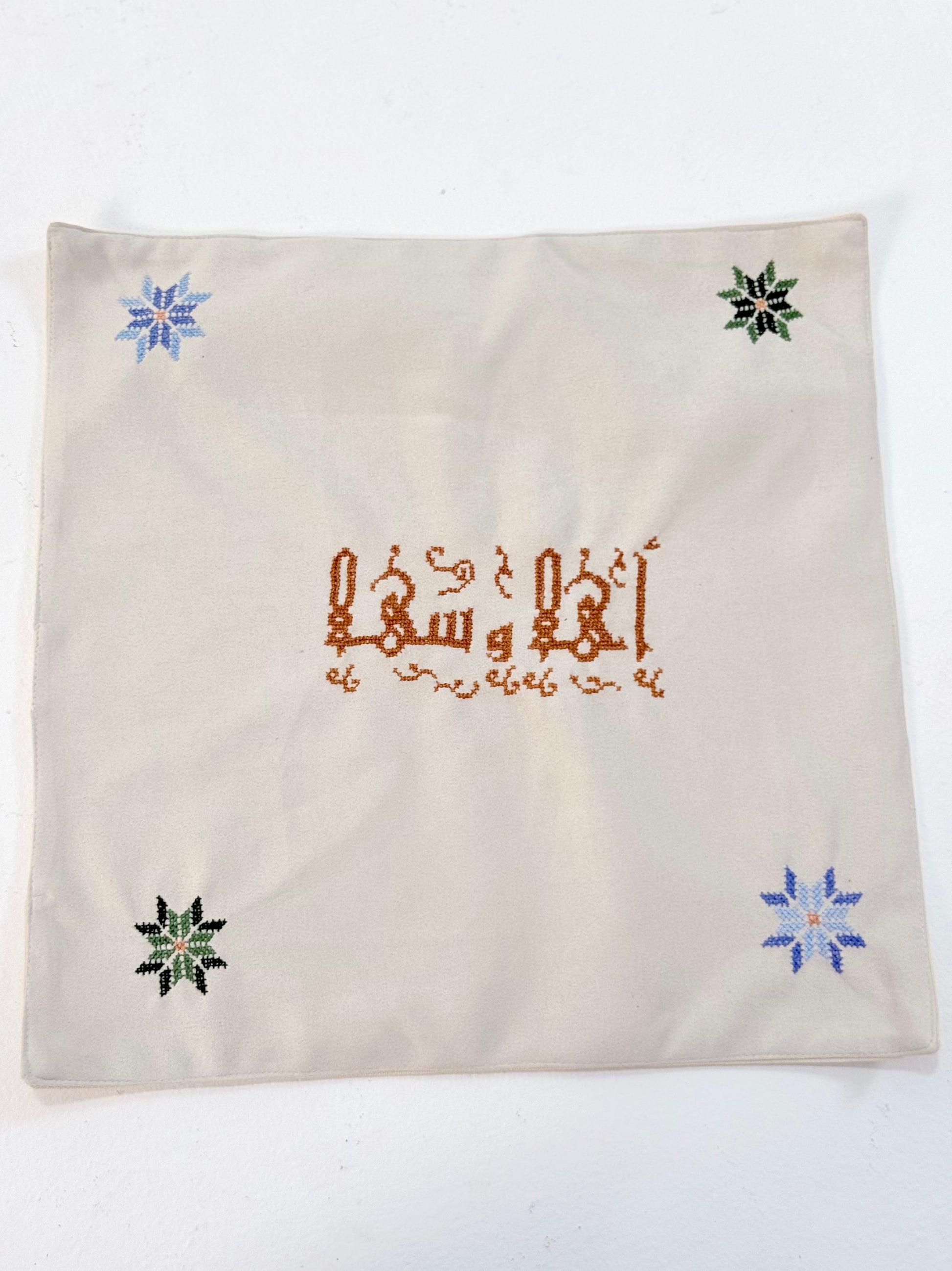 Handmade embroidered bread basket covers with traditional Palestinian tatreez in Arabic script, accented with small star motifs, crafted by women artisans in Palestine and Jordan, bringing heritage and warmth to your dining table.