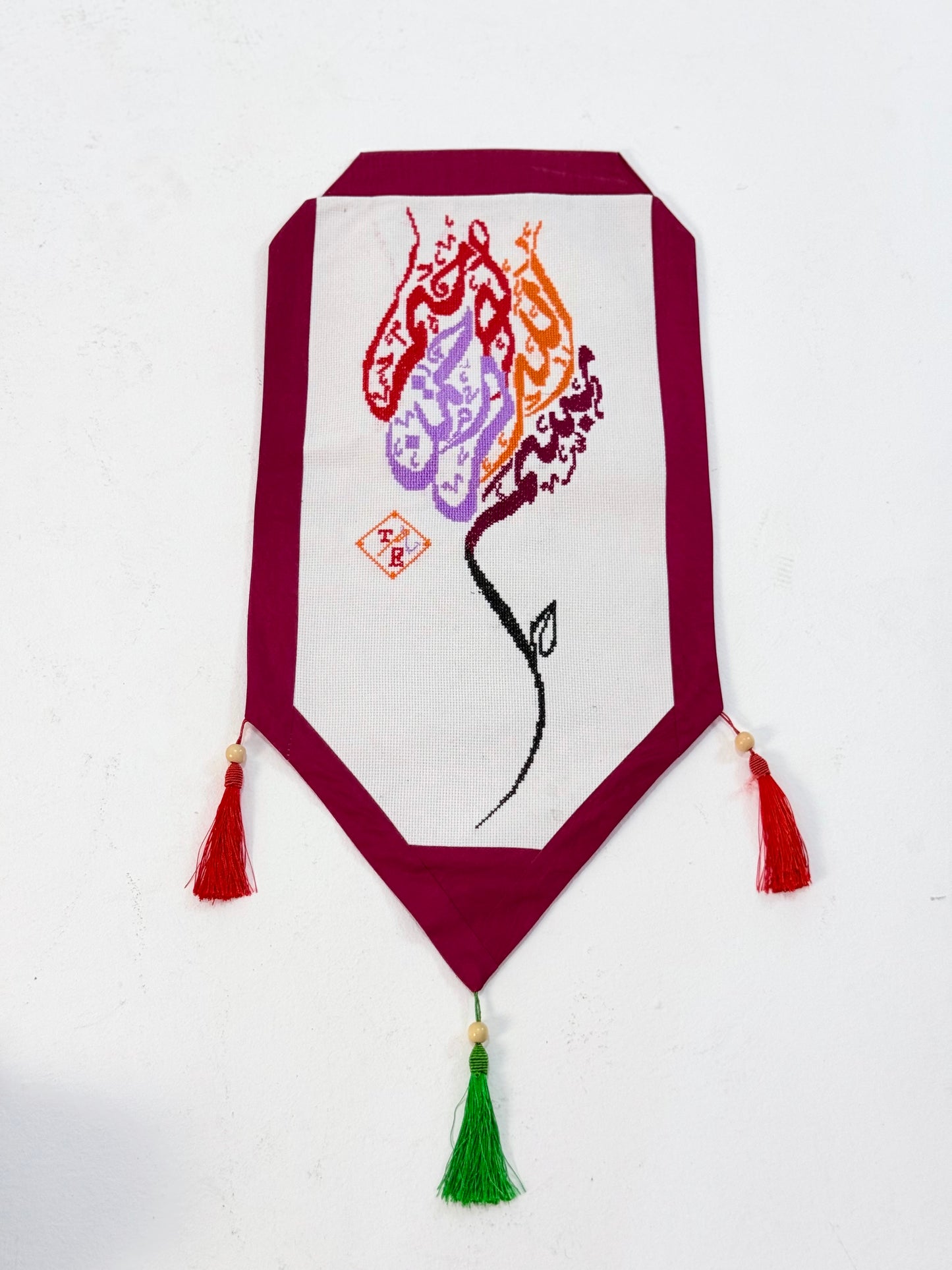 Handmade Mo’allaqa embroidered wall hanging with Bismillah calligraphy in vibrant colors, crafted by Palestinian women artisans.