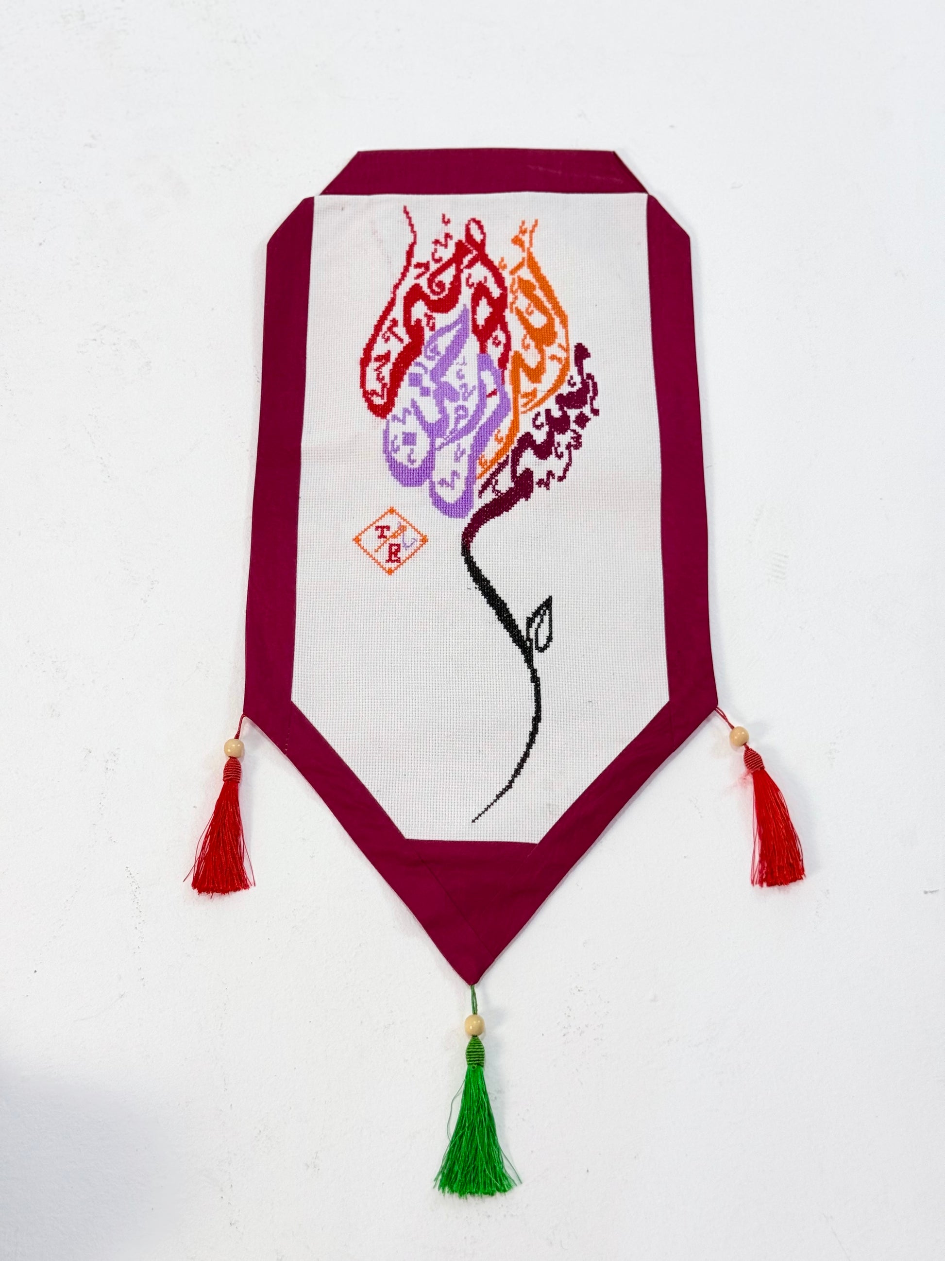 Handmade Mo’allaqa embroidered wall hanging with Bismillah calligraphy in vibrant colors, crafted by Palestinian women artisans.