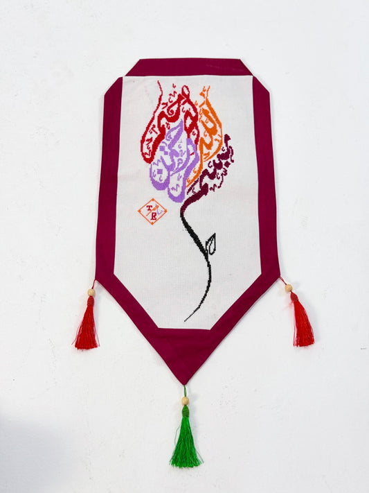 Handmade Mo’allaqa embroidered wall hanging with Bismillah calligraphy in vibrant colors, crafted by Palestinian women artisans.