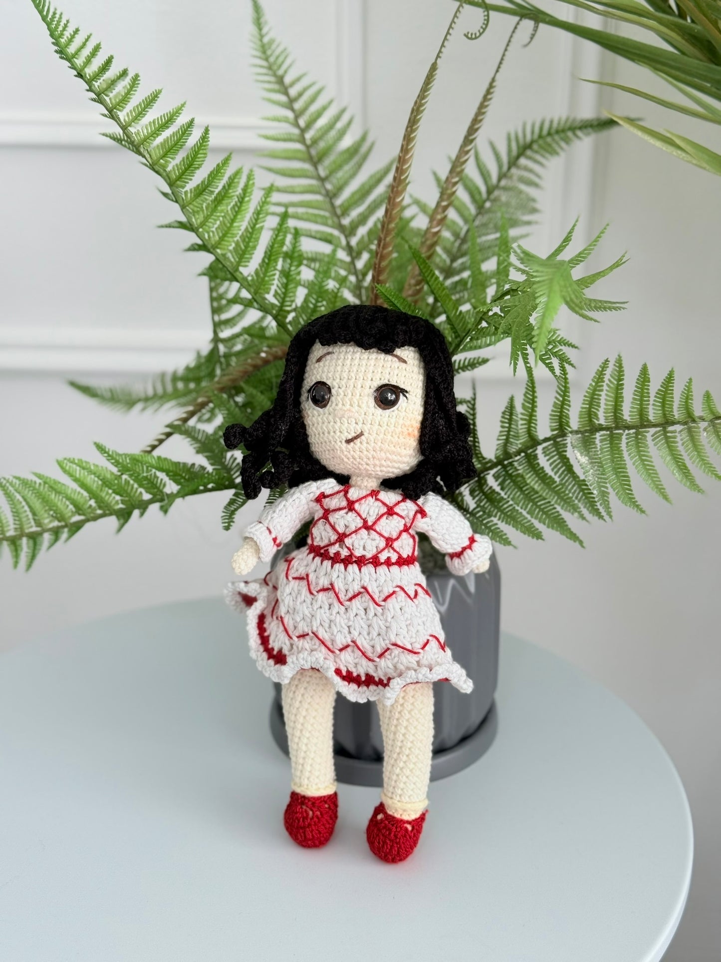 Handmade crochet Palestinian doll wearing kufiyeh-pattern dress, artisan toy supporting Palestinian heritage and culture