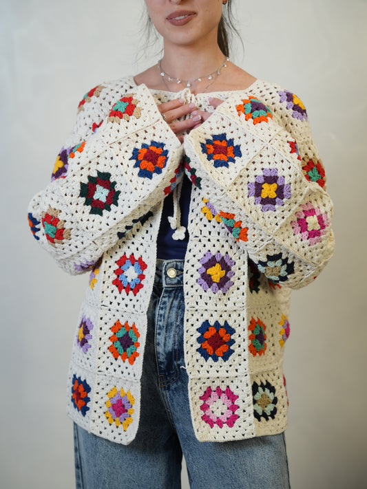 Handmade off-white crochet cardigan with colorful square motifs, crafted by women artisans.
