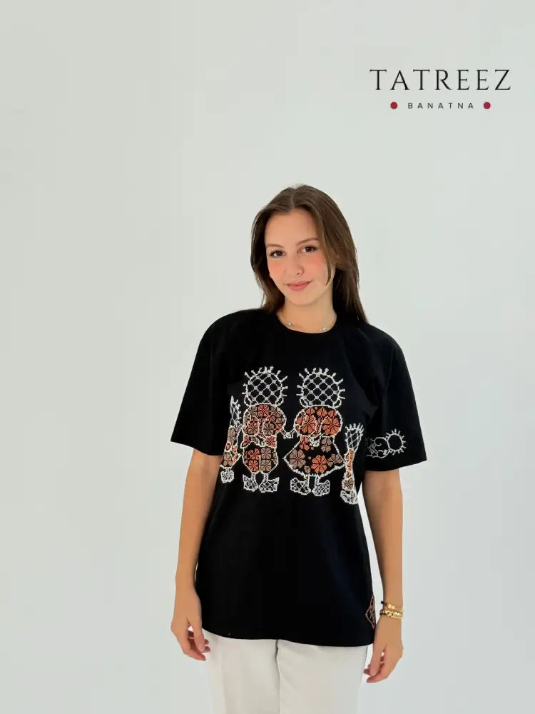 Black cotton T-shirt with Handhala family embroidered in white and beige, featuring iconic pose on the sleeve and brand logo.