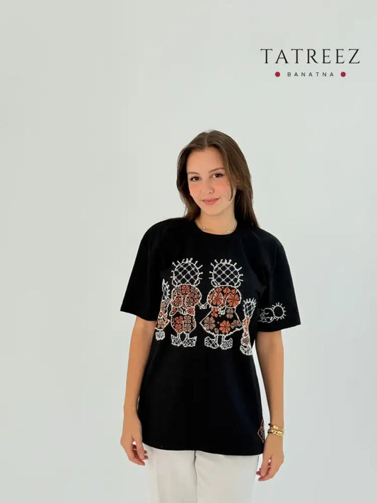 Black cotton T-shirt with Handhala family embroidered in white and beige, featuring iconic pose on the sleeve and brand logo.