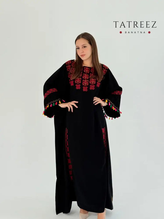 Handmade black Crepe Georgette abaya featuring Palestinian Tatreez embroidery and colorful tassel accents on the chest, hands, and sides.