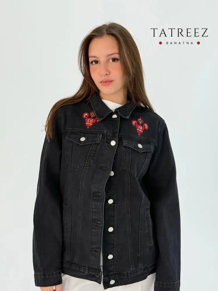 Black jeans jacket with bright blue, orange, yellow, and red embroidery on the front and back, showcasing a passionate and detailed design.