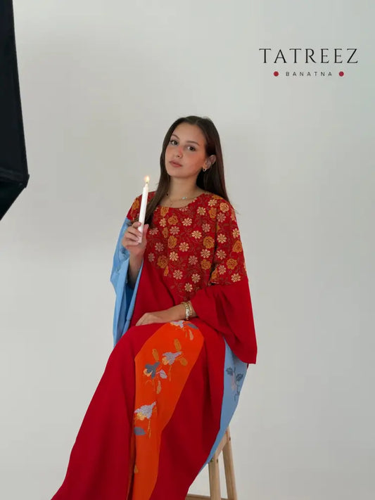 Handmade colorful layered abaya in soft linen, featuring light blue, red, and orange colors with floral designs and Palestinian embroidery.
