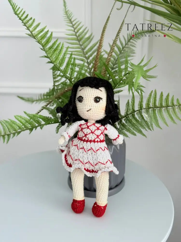Handmade crochet Palestinian doll wearing kufiyeh-pattern dress, artisan toy supporting Palestinian heritage and culture