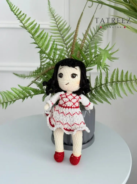 Handmade crochet Palestinian doll wearing kufiyeh-pattern dress, artisan toy supporting Palestinian heritage and culture