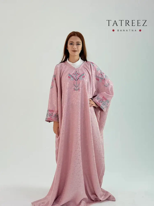Elegant pink farasha abaya made from crepe jacquard fabric, featuring beautiful handmade embroidery by Banatna artisans, free size with a length of 148 cm, customizable upon request.