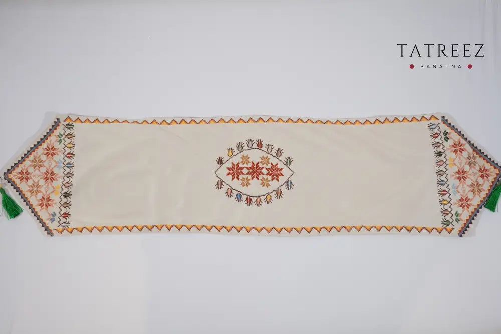 Hand-embroidered suede table runners featuring elegant Palestinian tatreez floral and geometric designs on turquoise and beige backgrounds, handmade by Palestinian, Jordanian, Lebanese, and Syrian women artisans seeking financial independence while preserving regional heritage.