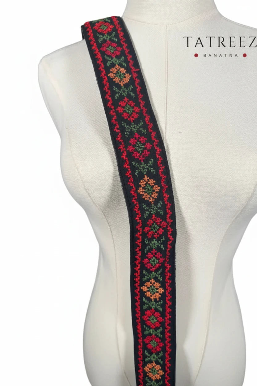 Eco-friendly bag strap in vibrant red, green, orange, and black colors, designed to support a cause.