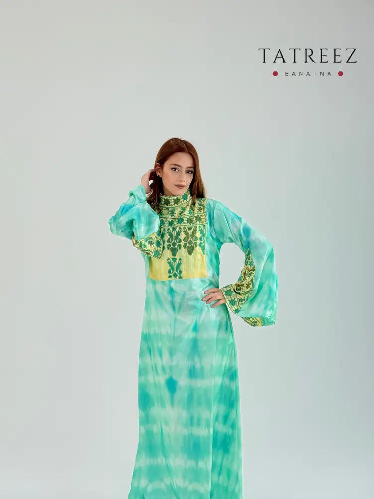 Elegant green and yellow abaya made from luxurious tefta fabric, featuring intricate handmade embroidery on the chest and sleeves, with a gold underlay, customizable to fit perfectly.
